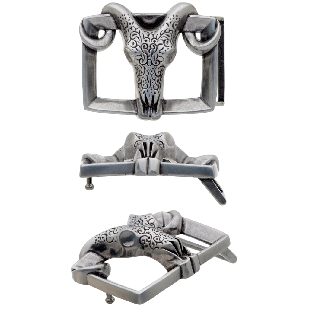 A detailed, rectangular silver belt buckle. This unique fashion accessory features a central sculpted ram's skull with horns and ornate patterns. The image shows the buckle from multiple angles.