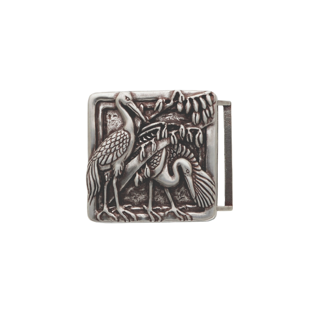 Detailed square silver belt buckle with a raised textured design of two herons or cranes and foliage, a unique fashion accessory with a beautiful Italian design.