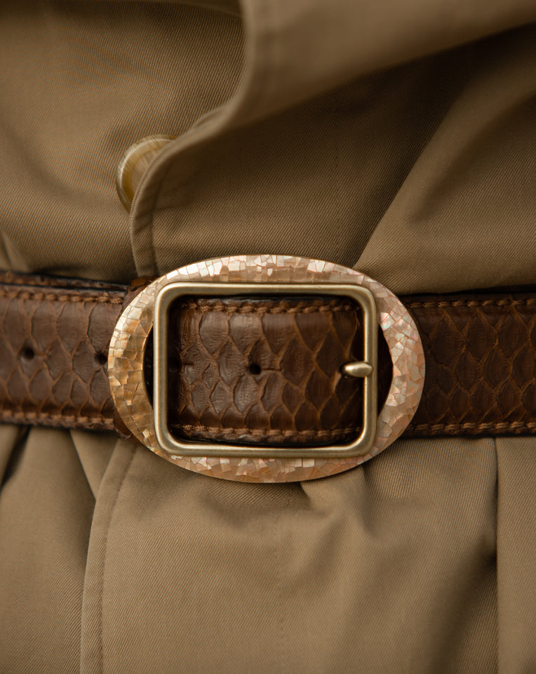 Antique gold oval belt buckle with a shimmering mother-of-pearl mosaic frame on a brown snakeskin leather belt.